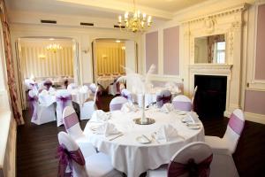 威灵堡雌鹿酒店的宴会厅配有白色的桌子和白色的椅子