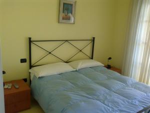 圣塔马利奈拉勒托里酒店的一间卧室配有一张带蓝色床单的大床