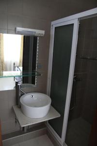 康隆尼角Les Trois Fleurs的一间带水槽和玻璃淋浴的浴室