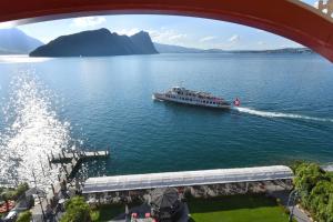 菲茨瑙Hotel Vitznauerhof - Lifestyle Hideaway at Lake Lucerne的桥下的船上