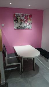 巴黎玛黑区之珠公寓的粉红色墙壁的房间里一张桌子和一把椅子