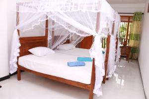 米瑞莎Dilara Resort Mirissa的一间卧室配有一张带天蓬的床