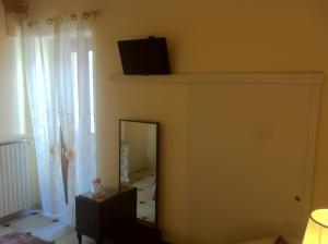 梅萨涅Porta Piccola B&B的一间设有镜子的客房,墙上配有电视