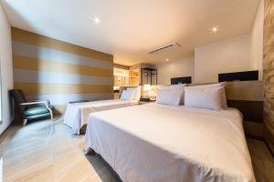 首尔SB汝矣岛精品酒店的酒店客房,配有两张床和椅子
