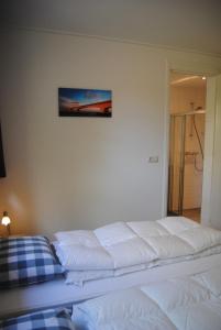 东卡佩勒Dunopark Villa的卧室内的一张白色床,墙上挂着一幅画