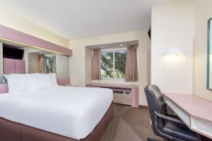 艾伦镇埃伦敦骑士旅馆的酒店客房设有一张大床和一张书桌。