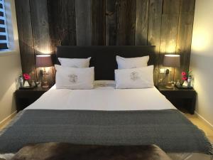 布鲁日16号住宿加早餐旅馆的一间卧室配有一张带两盏灯的大型白色床。