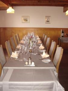 Egnach兰德加斯托温泽尔贝格酒店的长桌,带酒杯和餐巾