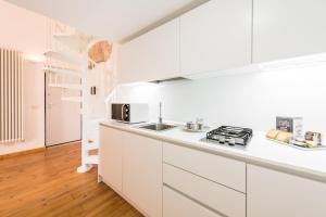 巴里巴里市中心艺术阁楼M8公寓的白色的厨房设有水槽和炉灶。