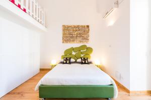 巴里巴里市中心艺术阁楼M8公寓的一间卧室设有绿色的床和白色的墙壁