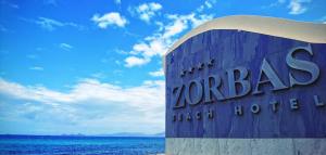蒂加基索帕斯海滩酒店的海滩上的Zorba酒店标志