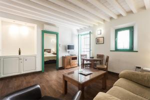 格拉纳达桂冠套房公寓的客厅配有沙发和桌子