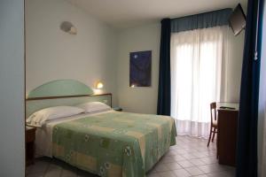 索威拉托玛里纳格里乌丽维酒店的一间卧室配有一张带绿色床罩的床和窗户。