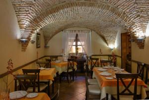 纳瓦斯-德尔马德罗尼奥Casa Rural La Chimenea的一间带桌椅的餐厅以及砖砌天花板
