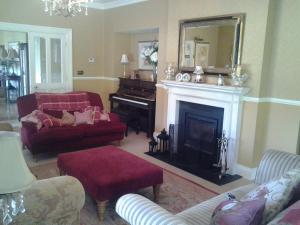 利特里姆Drumhierney Lodge的客厅设有壁炉和钢琴。
