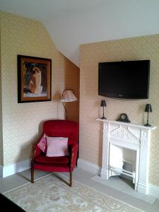 利特里姆Drumhierney Lodge的客厅设有红色椅子和壁炉
