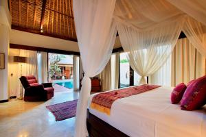 沙努尔Manzelejepun Luxury Villa & Pavilion的一间卧室配有一张带天蓬的床
