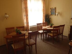 特普利采绿屋酒店的用餐室配有木桌、椅子和窗户