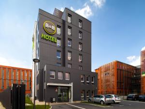 舍维伊拉吕B&B HOTEL Orly Chevilly Marché International的一座黑色的大建筑,上面有酒店标志