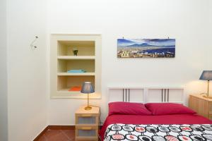 那不勒斯Residenza Santa Chiara的一间卧室设有红色的床和白色的墙壁