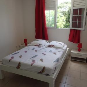 Rivière-PiloteLa créola BAYALOCATION的卧室内的一张带白色棉被和枕头的床