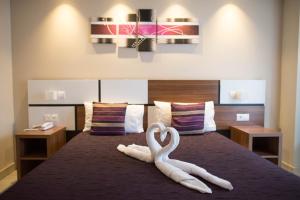 滨海萨纳里Holidays & Work HOTEL的床上用毛巾制成的两天鹅