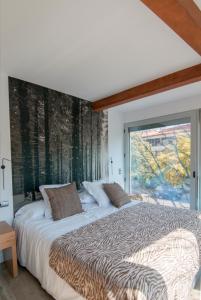 奥尔加尼亚Cal Tonarro的一间卧室设有一张大床和大窗户