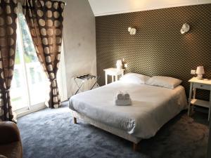 萨韦奈Hôtel Restaurant Logis Coté Lac的一间卧室配有一张床,上面有两条毛巾