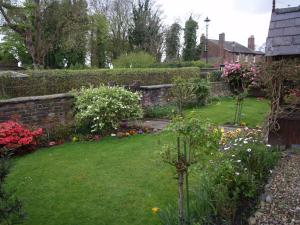 HaleChurch End Farm Bed and Breakfast的鲜花盛开的花园,砖墙