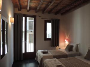 莫雷拉Casa Rural Vistes de Morella的一间卧室设有两张床和窗户。