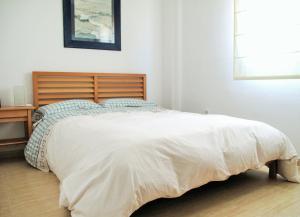 阿尔么丽亚Atico Alhamilla的一间卧室配有一张大床和木制床头板