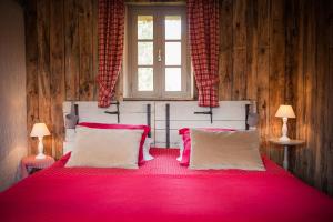 托德弗赫库姆勒多雷住宿加早餐旅馆的一间卧室配有一张红色大床和两盏灯