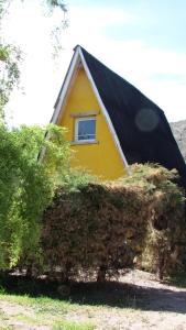 波特雷里约斯Complejo de Cabañas Tierra de Luna的黄色的房子,有黑色的屋顶和窗户