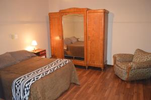 门多萨马洛卡酒店的一间卧室配有一张床、镜子和椅子
