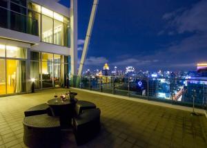 曼谷优本纳 沙通的大楼的阳台,配有桌椅