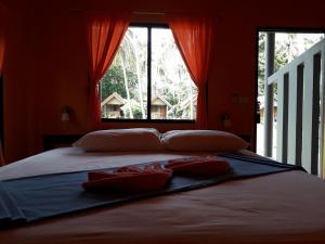 高兰青辣椒简易别墅度假酒店的卧室设有一张带红色墙壁和窗户的大床