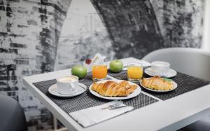 里斯本里斯本圣本托酒店的一张桌子,早餐包括羊角面包和橙汁