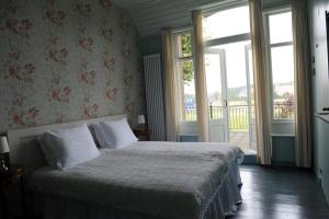 OostwoldMoushouk Bed and Breakfast的一间卧室配有一张床,阳台配有窗户