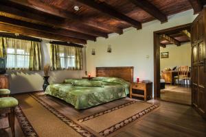 Sredni KolibiElenski Riton Complex的一间卧室设有绿色的床和木制天花板