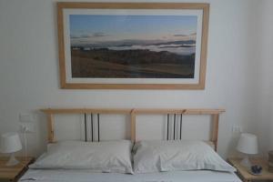 蒙泰斯佩尔托利La Medialuna的床上挂着一张图画,上面有两个枕头
