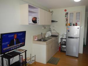 达沃市One Oasis Condotel的厨房配有电视、水槽和冰箱。