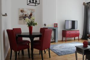 莱比锡莱昂套房公寓 的一间带桌椅和电视的用餐室