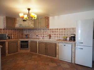 马诺斯克campagne de pimayon的厨房配有木制橱柜和白色冰箱。