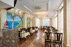 索契索纳塔酒店的一间带桌椅和吊灯的用餐室