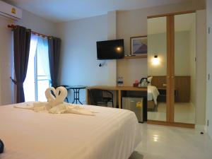 奈扬海滩Winrisa Place的酒店客房,配有一张带毛巾的床铺,享有心形