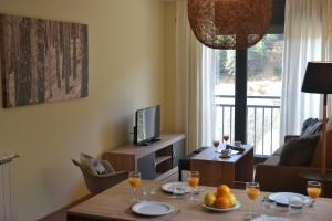博尔德斯·代瓦里拉Pierre & Vacances Andorra Sunari Peretol的客厅配有桌子和电视
