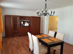 莫雄马扎尔古堡Apartman Kaszás Central的一间用餐室,配有黑桌和白色椅子