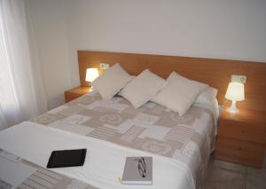 菲格拉斯Barceloneta UPartments的一间卧室配有一张床,上面有一本书