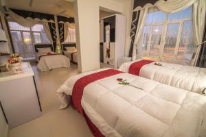 MawāliḩAl Mawaleh Furnished Flats & Rooms的一间卧室配有两张鲜花床。