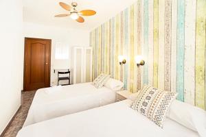 巴塞罗那费拉旅馆的一间卧室配有两张床和吊扇